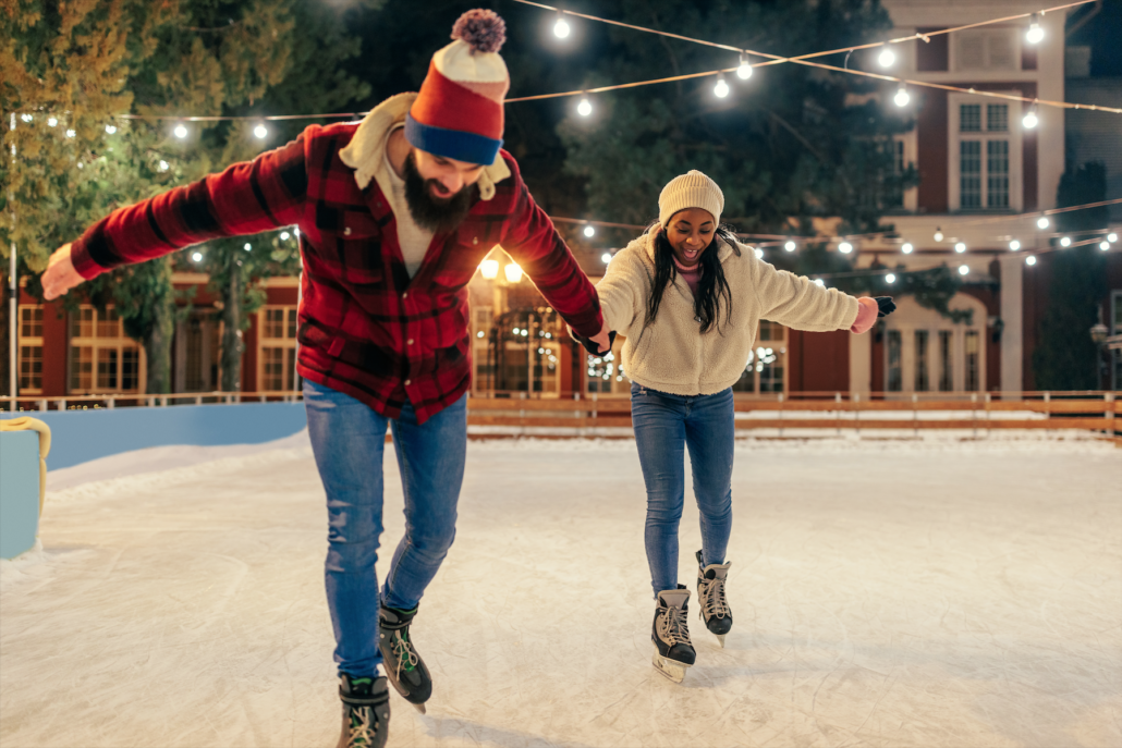 Winter Date-Ideen: Junges Paar hat gemeinsam Spaß beim Eislaufen