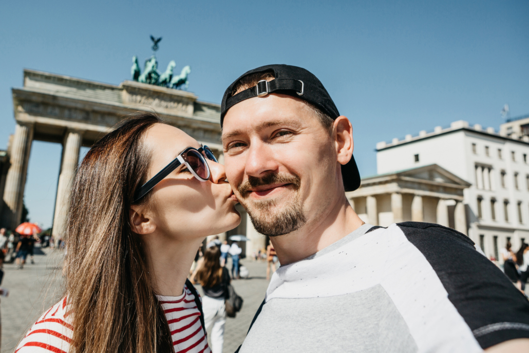 Date-Ideen in Berlin: Ein junges Paar vor dem Brandenburger Tor bei einem Date in Berlin.